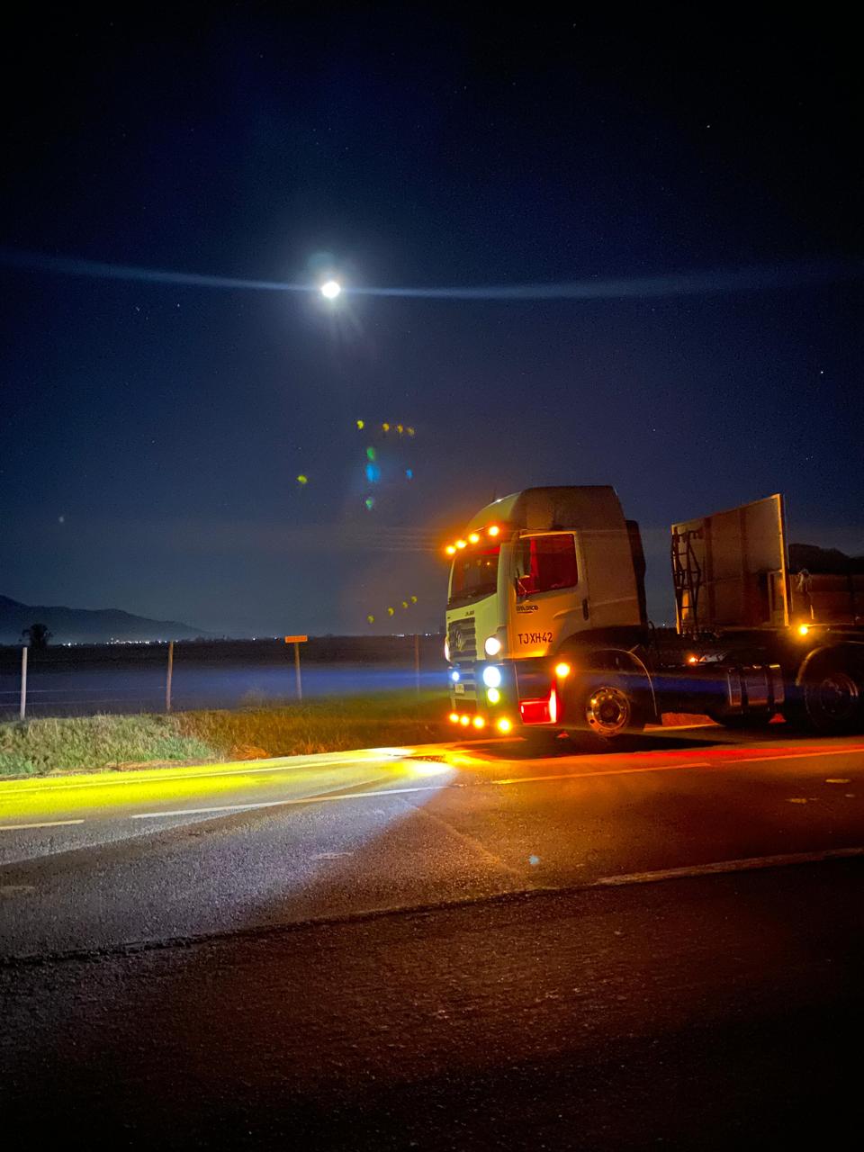 Camión de Transportes Quintana en ruta nocturna, símbolo de confianza y compromiso en el transporte de carga.